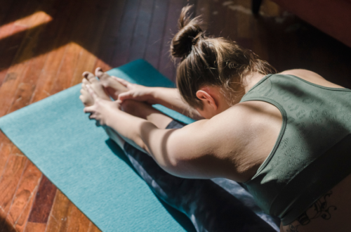 A brunette woman stretching on a yogamat